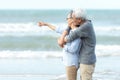 Asian Lifestyle senior couple pointing and hug, stand see beach happy in love romantic and relax time.ÃÂ  Tourism elderly family tr Royalty Free Stock Photo